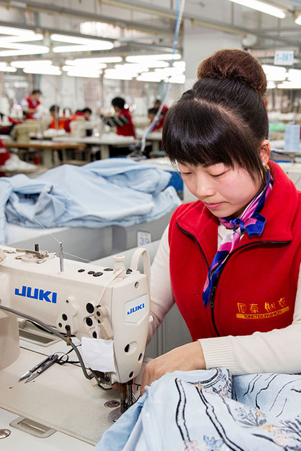  39/5000 woman working on a sewing machine